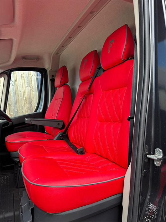 Red leather seating area in the driver area of a Piper Horseboxes Ltd horsebox.