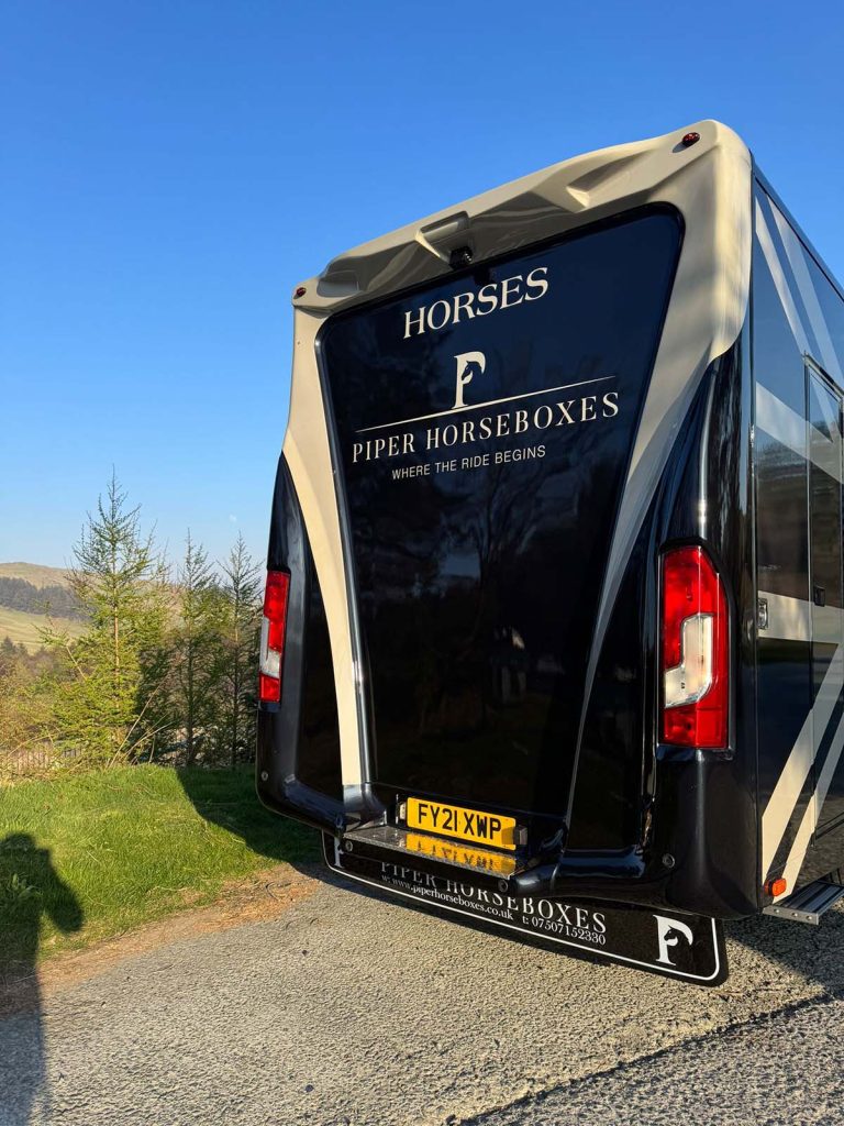 Rear view of a black and gold Piper Horseboxes Ltd custom horsebox.