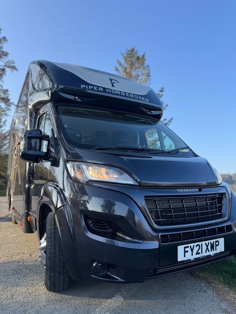 Front view of a black and gold Piper Horseboxes Ltd custom horsebox.