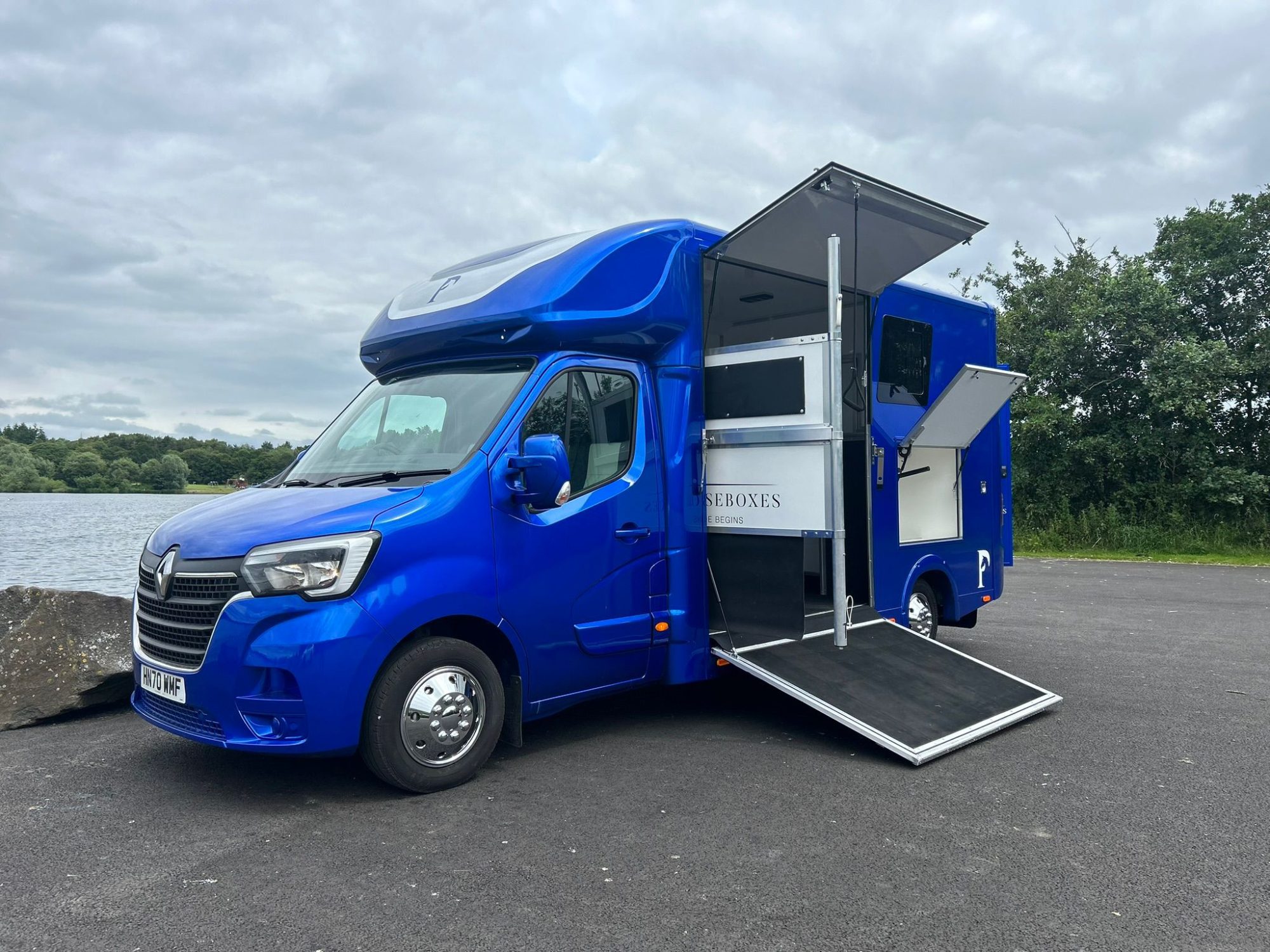 Equestrian preparing horse near a Piper Horseboxes Ltd vehicle.