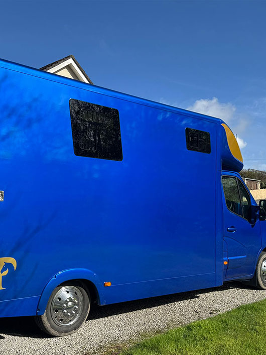 Side view of a blue and gold Piper Horseboxes Ltd horsebox in Lancashire. Perfect for horse shows and travel.